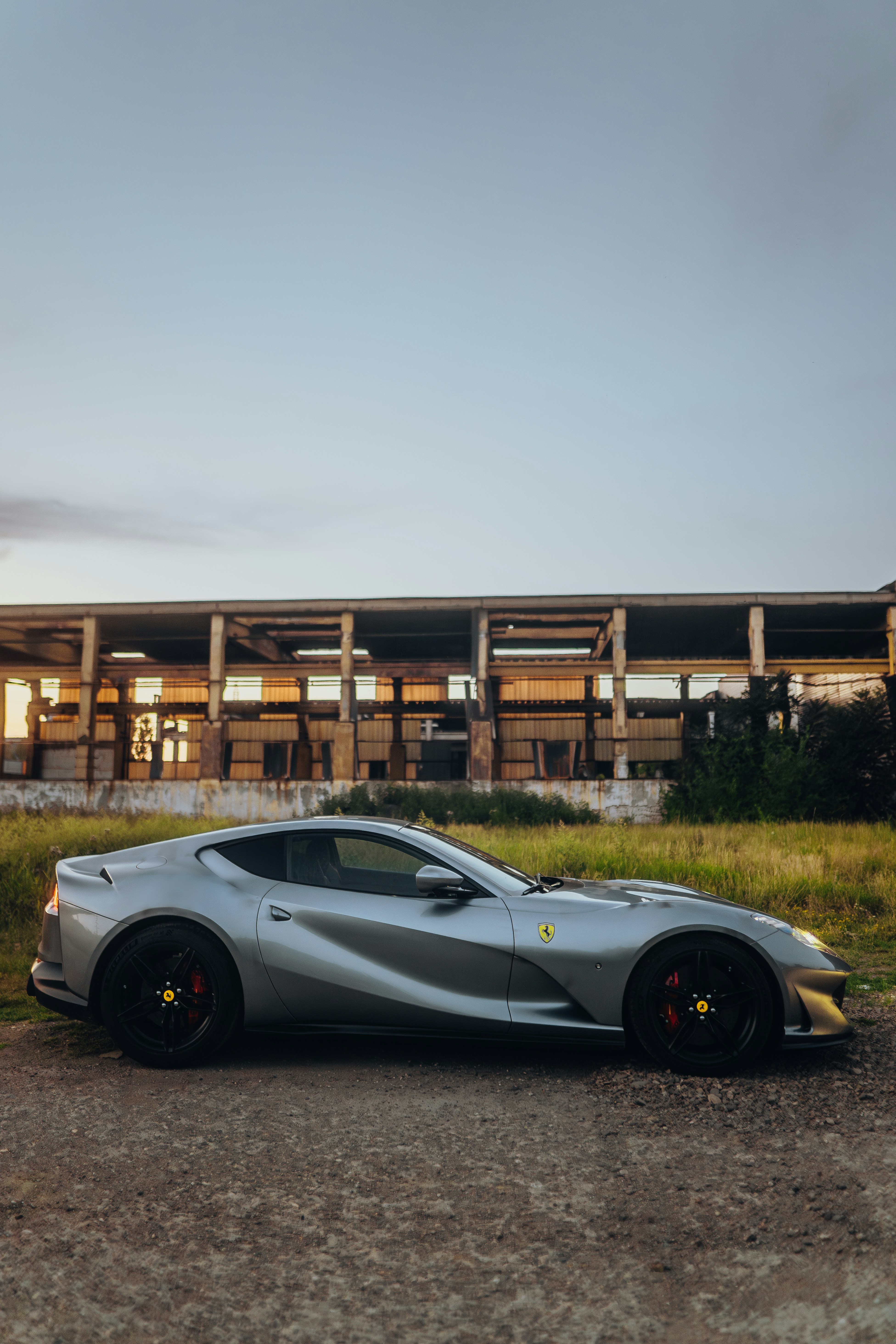 Une voiture de sport argentée garée devant un immeuble