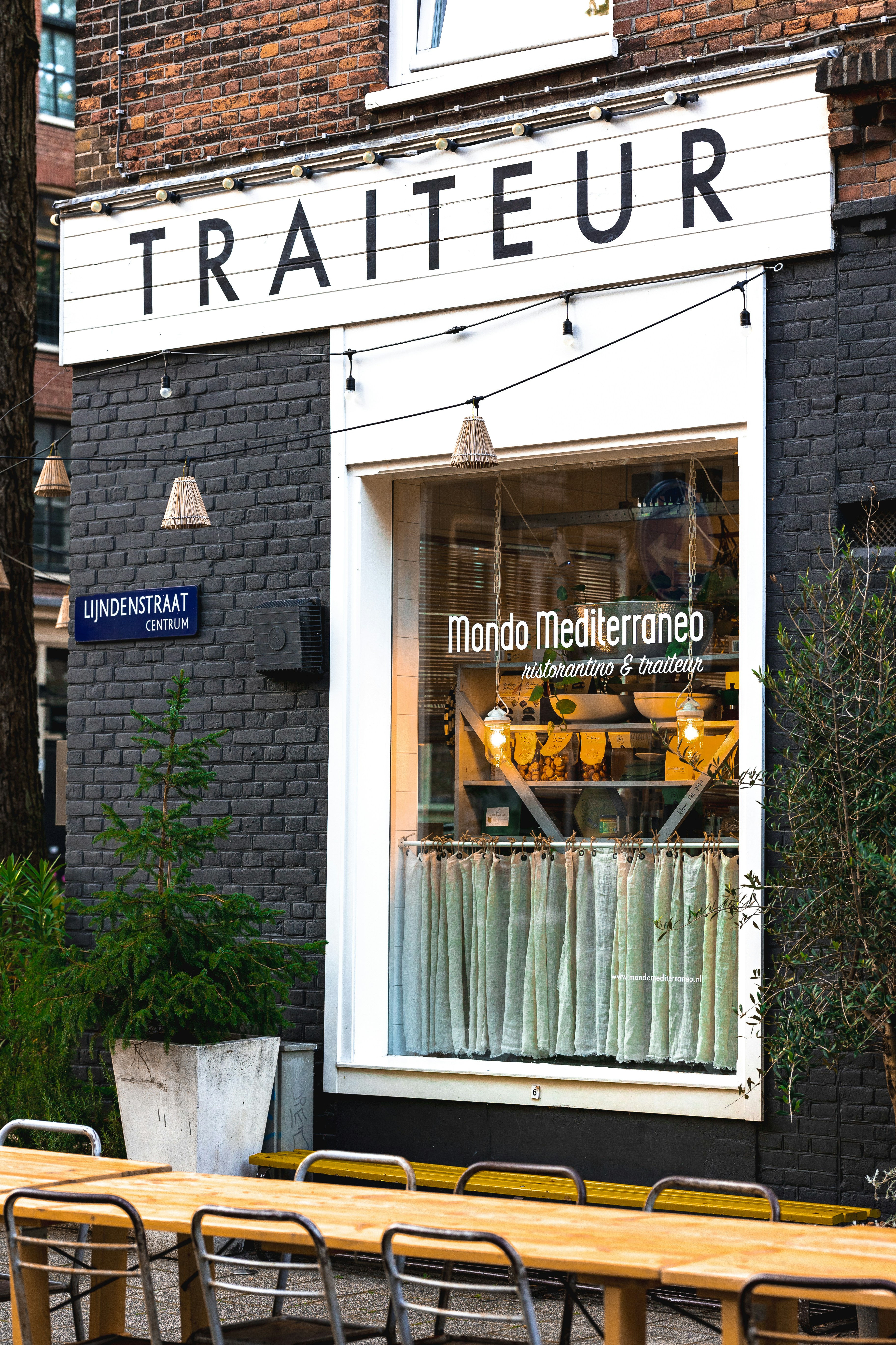a store front with tables and chairs outside of it
