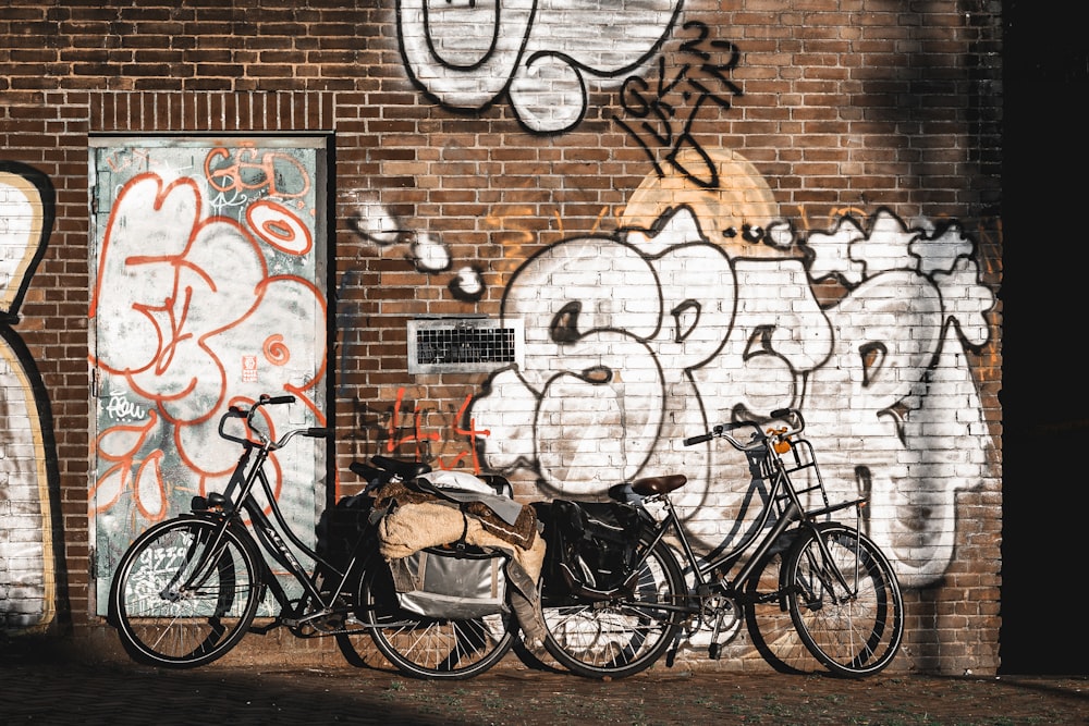 a couple of bikes parked next to a brick wall