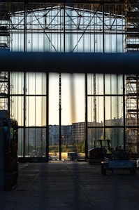Wide shot of a newly constructed industrial hall with gleaming metal framework under a clear sky.