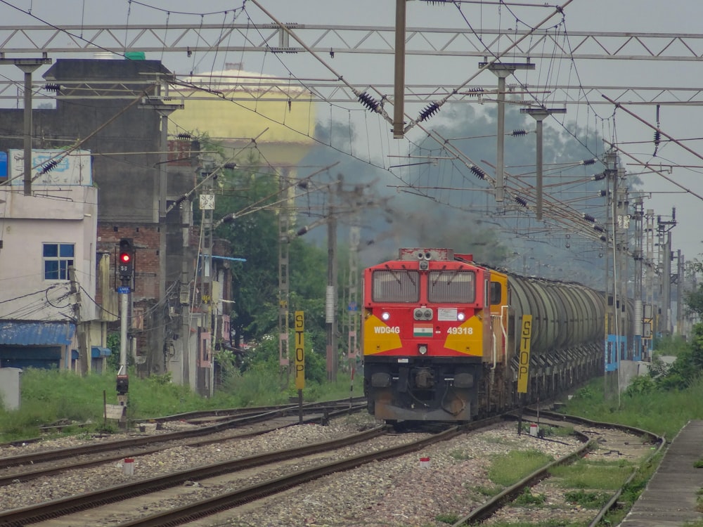 a red and yellow train traveling down train tracks