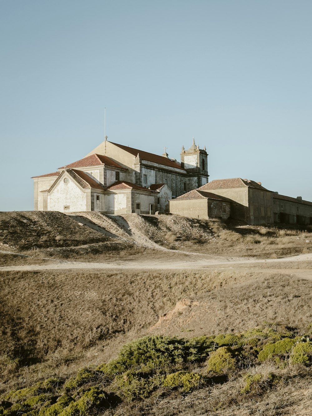 a large building sitting on top of a dirt hill