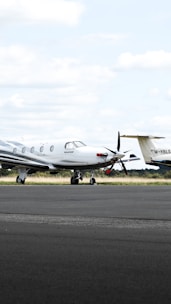 A pilot preparing a private jet for takeoff on a sunlit runway.