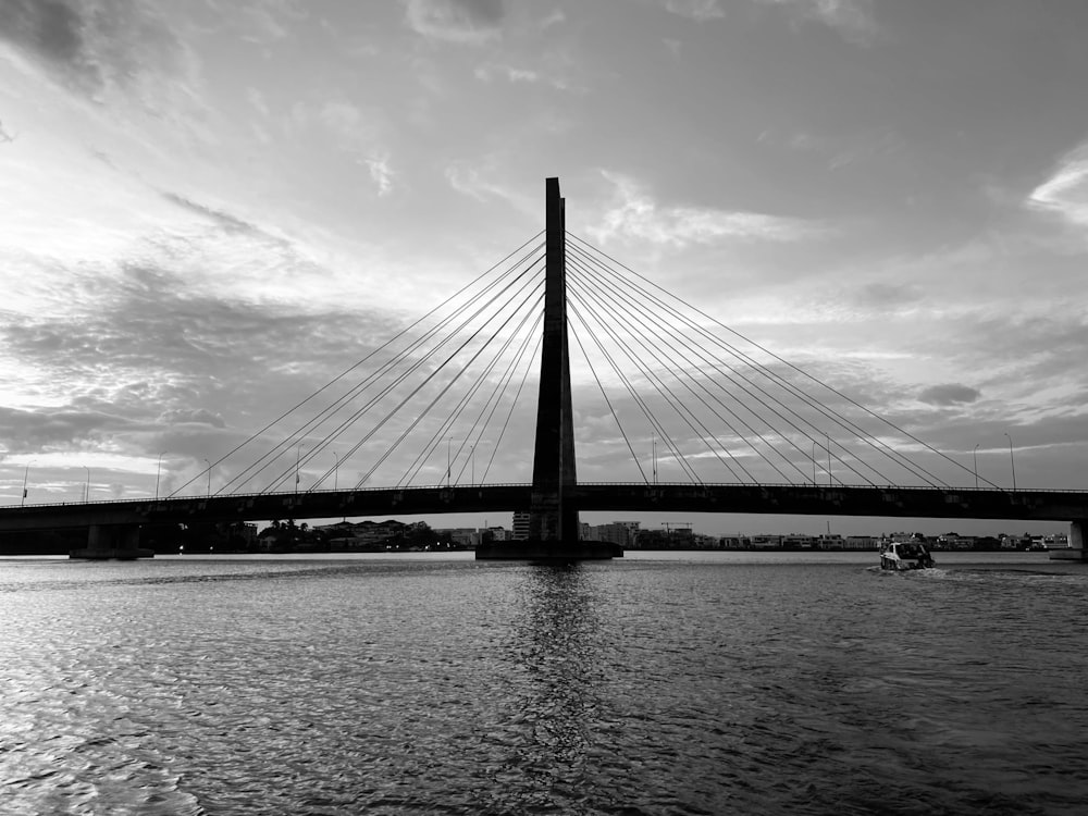 a black and white photo of a bridge over water