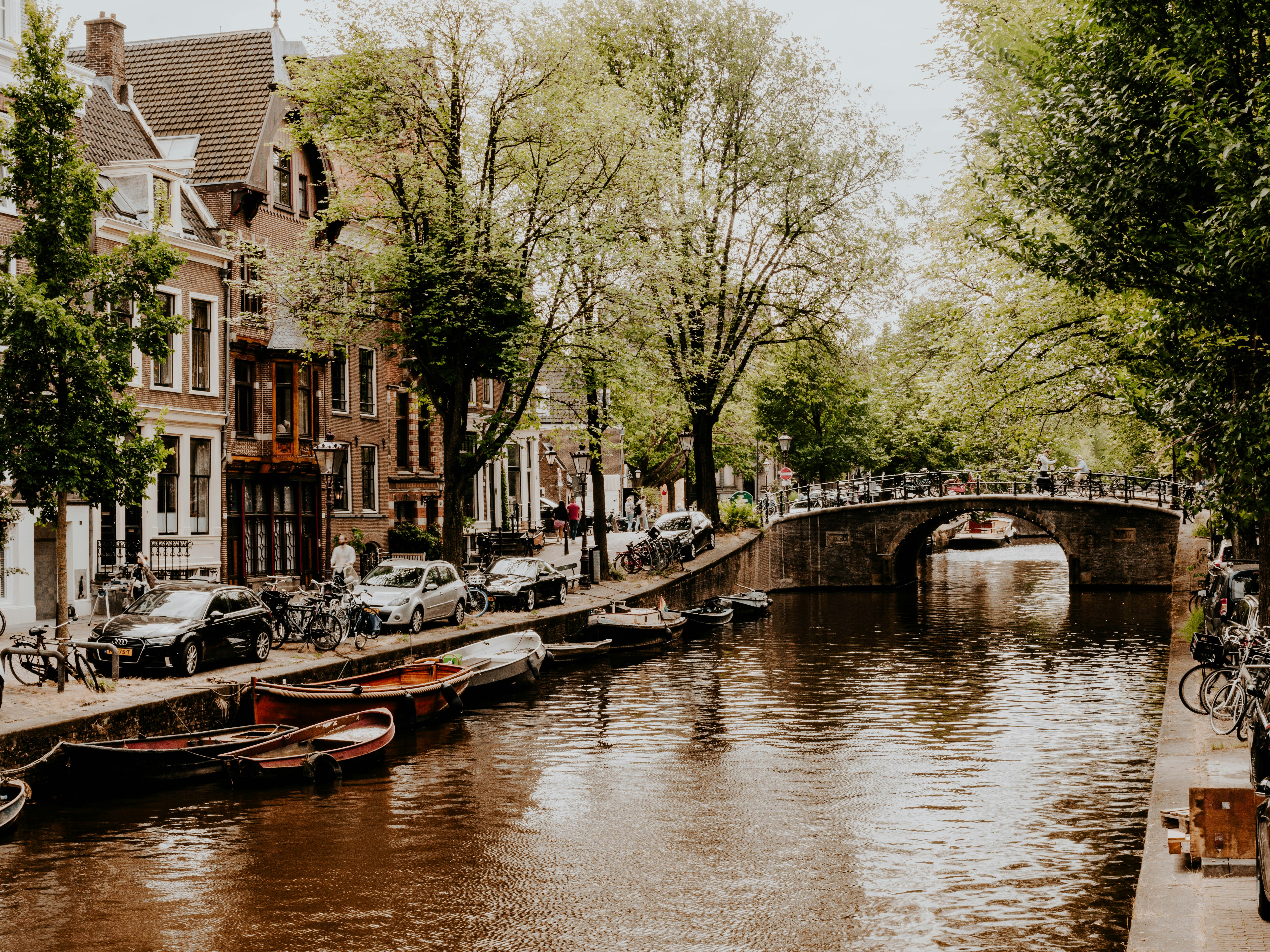 a canal with boats and bicycles parked along it, 