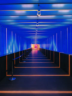 A hospital corridor bathed in soft blue light, highlighting advanced safety sensors discreetly integrated into the environment.