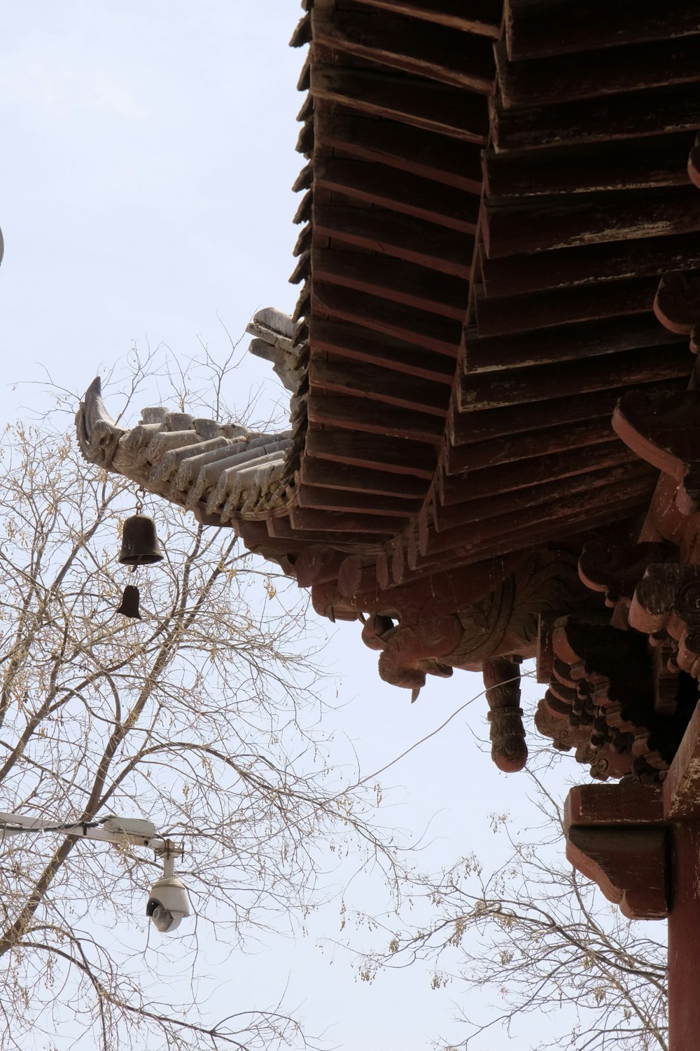 a view of the roof of a building with bells hanging from it