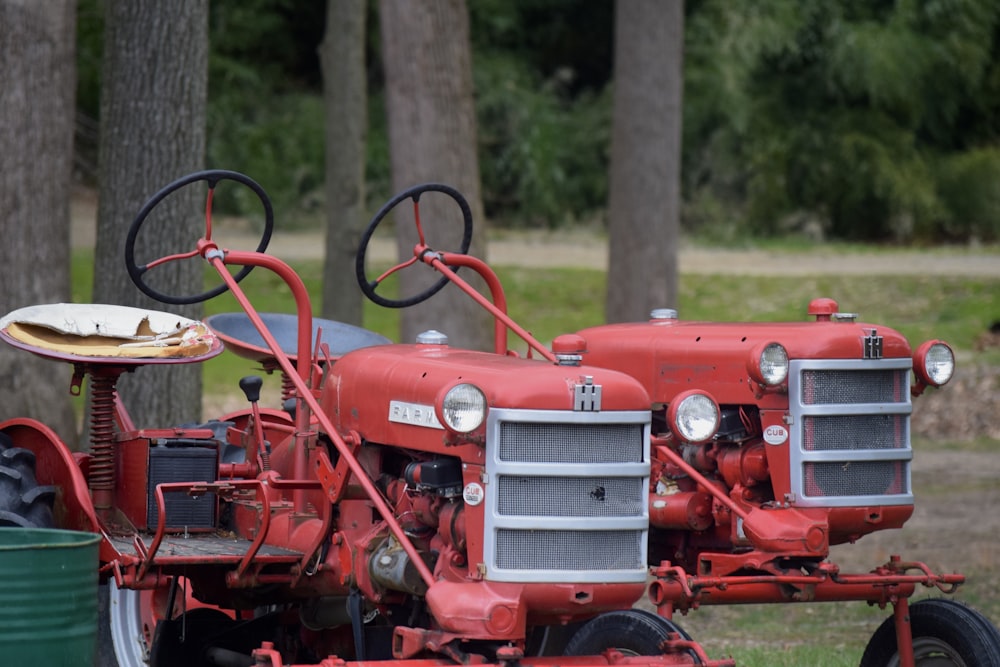 an old red tractor parked in a field