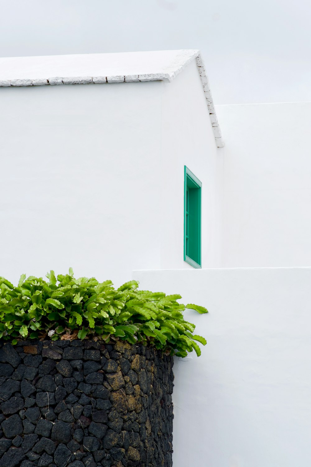 um edifício branco com uma porta e janela verdes