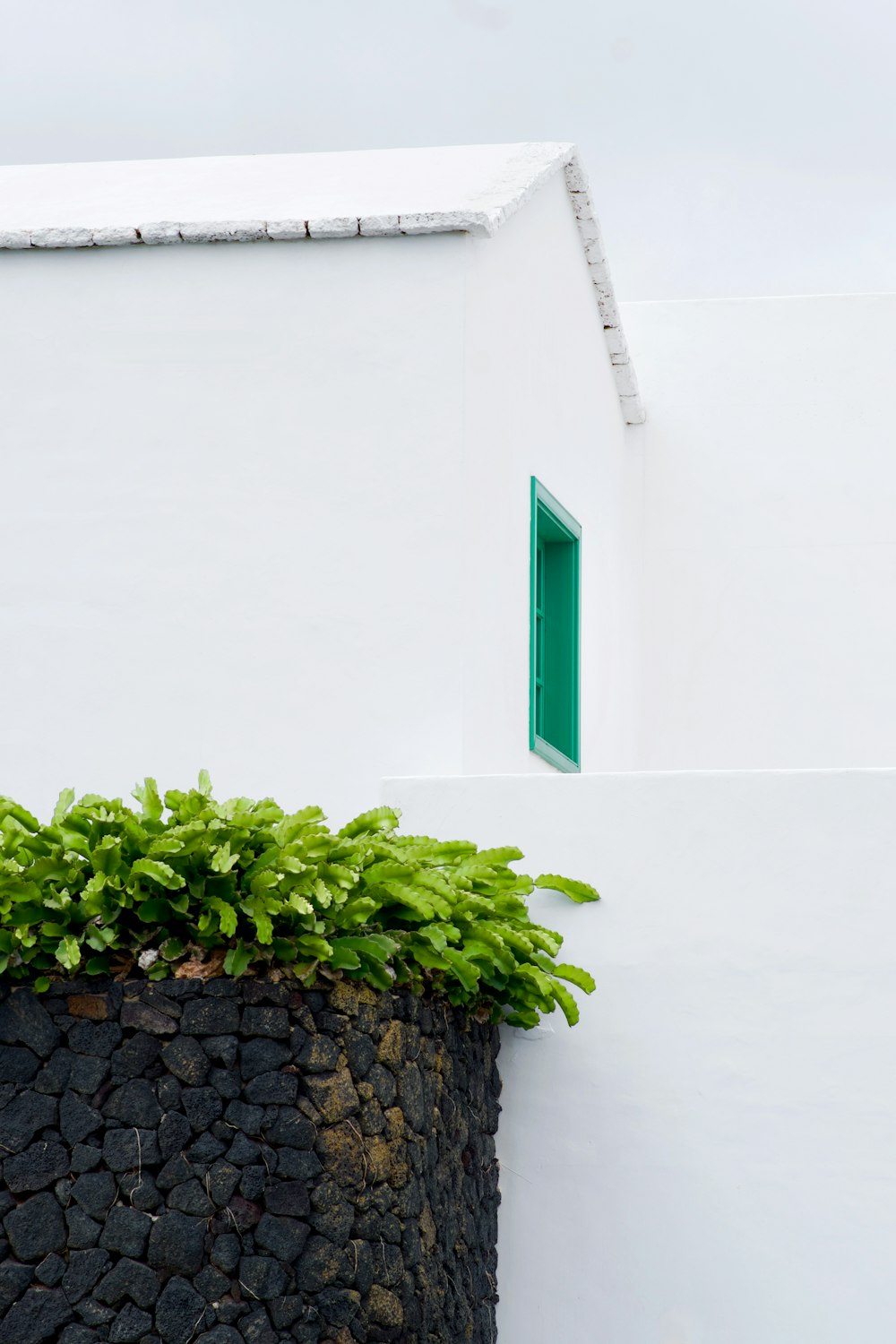 a white building with a green door and window