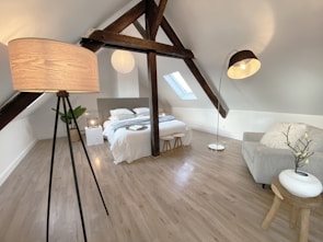 a room with a bed, a couch and a lamp