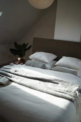 A neatly made bed with plush pillows and a soft duvet in calming neutral tones.