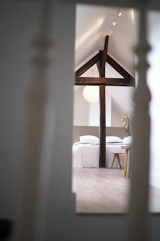 Brightly lit attic conversion with wooden beams and cozy decor