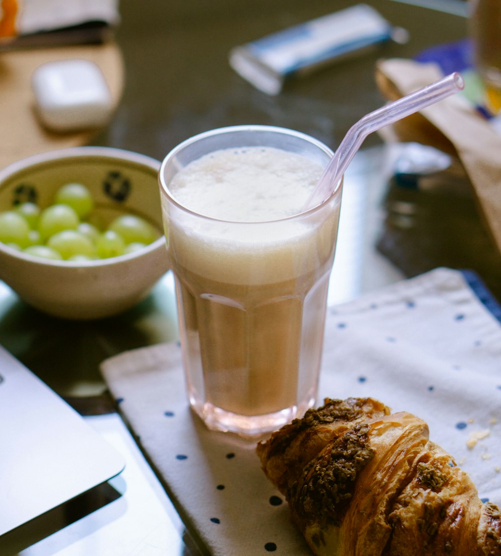 a glass of milk and a croissant on a napkin