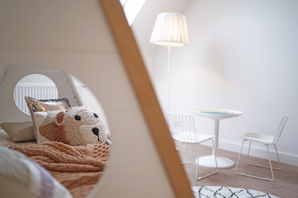 a teddy bear sitting on a bed in a room