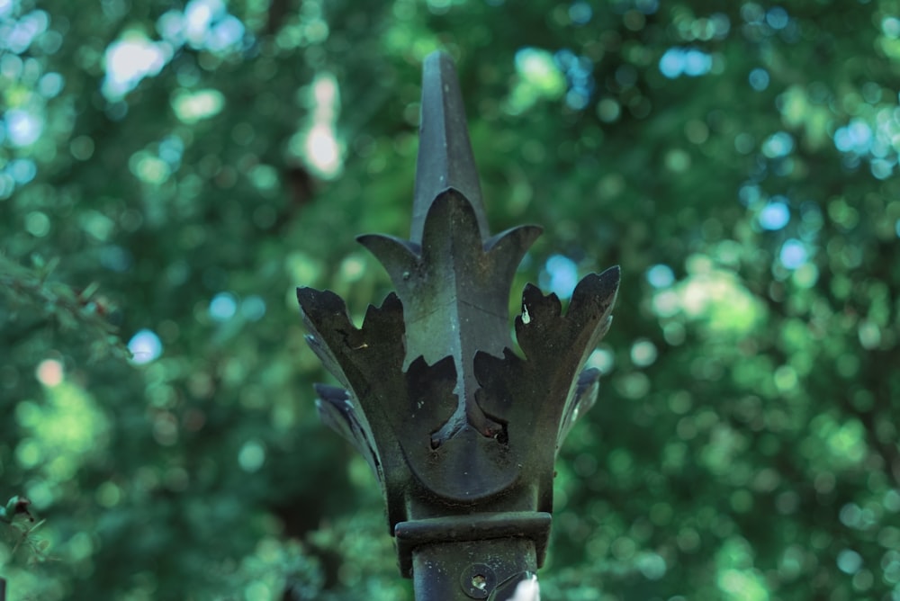 a close up of a metal object with trees in the background