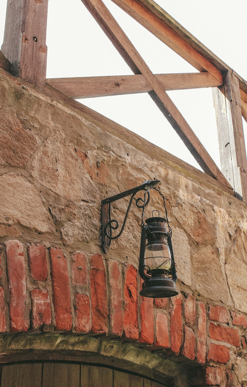 a brick wall with a lantern hanging from it