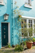 a blue building with a green door and window