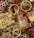 A collection of intricately painted wooden keychains with animal motifs, featuring vibrant colors and detailed patterns. The keychains include designs of animals with playful expressions, surrounded by gold rings and chains.