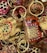 A collection of intricately painted wooden keychains with animal motifs, featuring vibrant colors and detailed patterns. The keychains include designs of animals with playful expressions, surrounded by gold rings and chains.