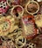 A collection of intricately painted wooden keychains with animal motifs, featuring vibrant colors and detailed patterns. The keychains include designs of animals with playful expressions, surrounded by gold rings and chains.