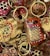A collection of intricately painted wooden keychains with animal motifs, featuring vibrant colors and detailed patterns. The keychains include designs of animals with playful expressions, surrounded by gold rings and chains.
