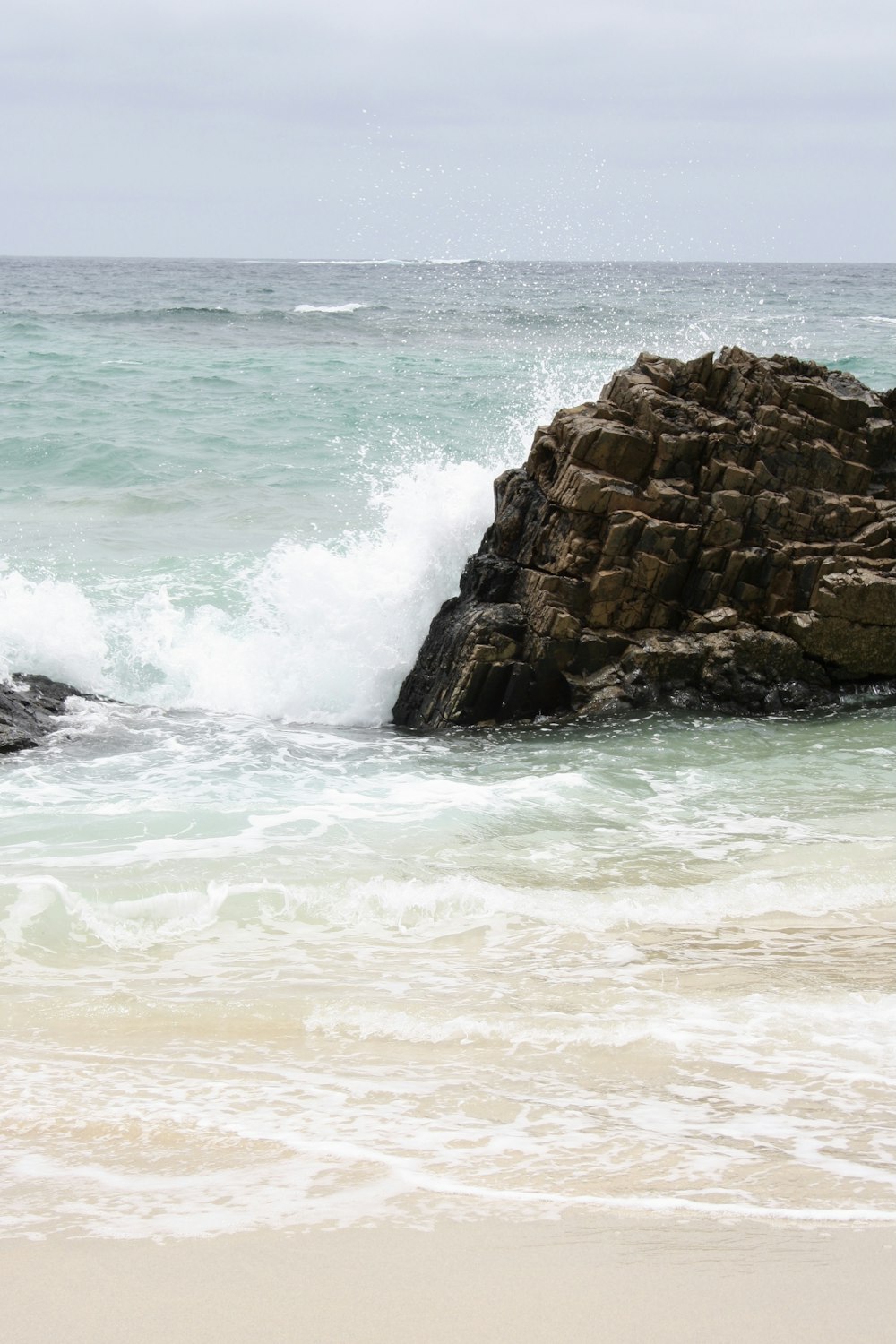 a large rock sticking out of the ocean