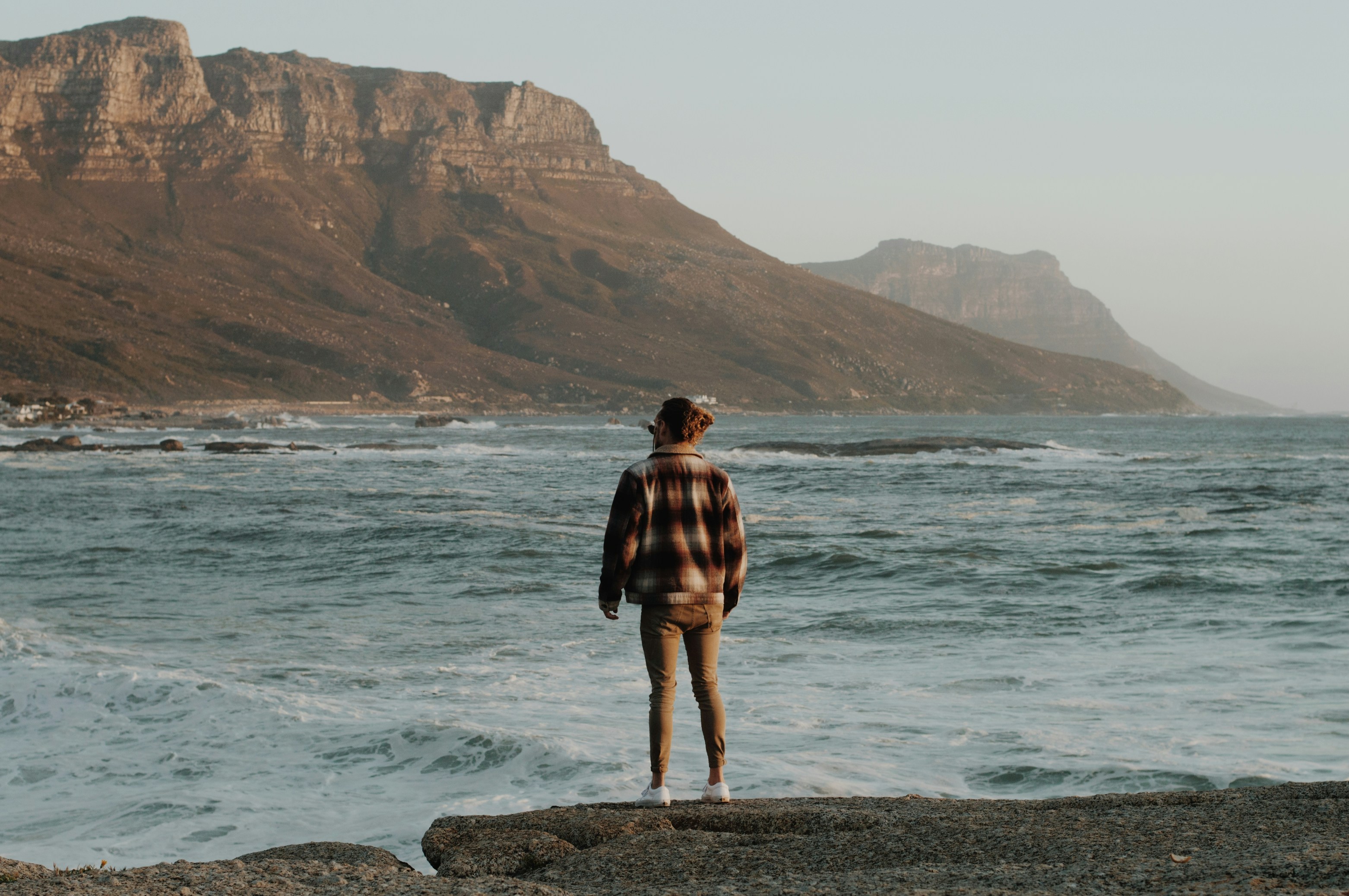 eine Person, die auf einem Felsen in der Nähe des Ozeans steht