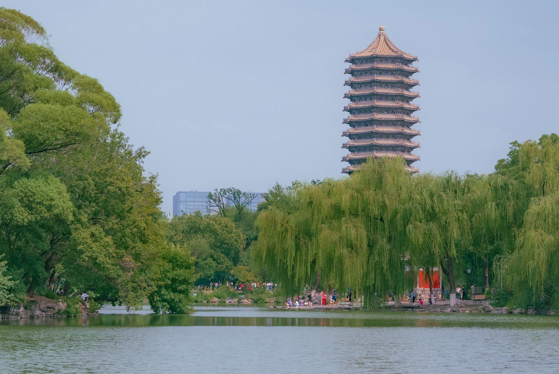 a tall tower towering over a lake surrounded by trees