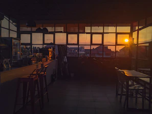 Sunset view through the café window with customers chatting and sipping coffee