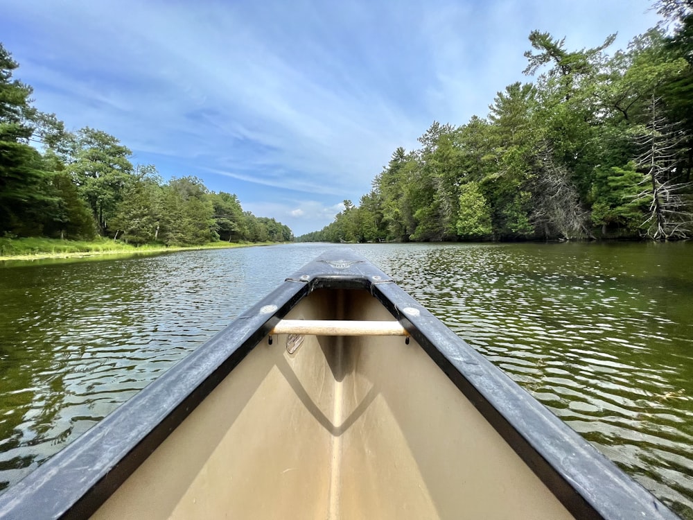 a boat traveling down a river next to a forest