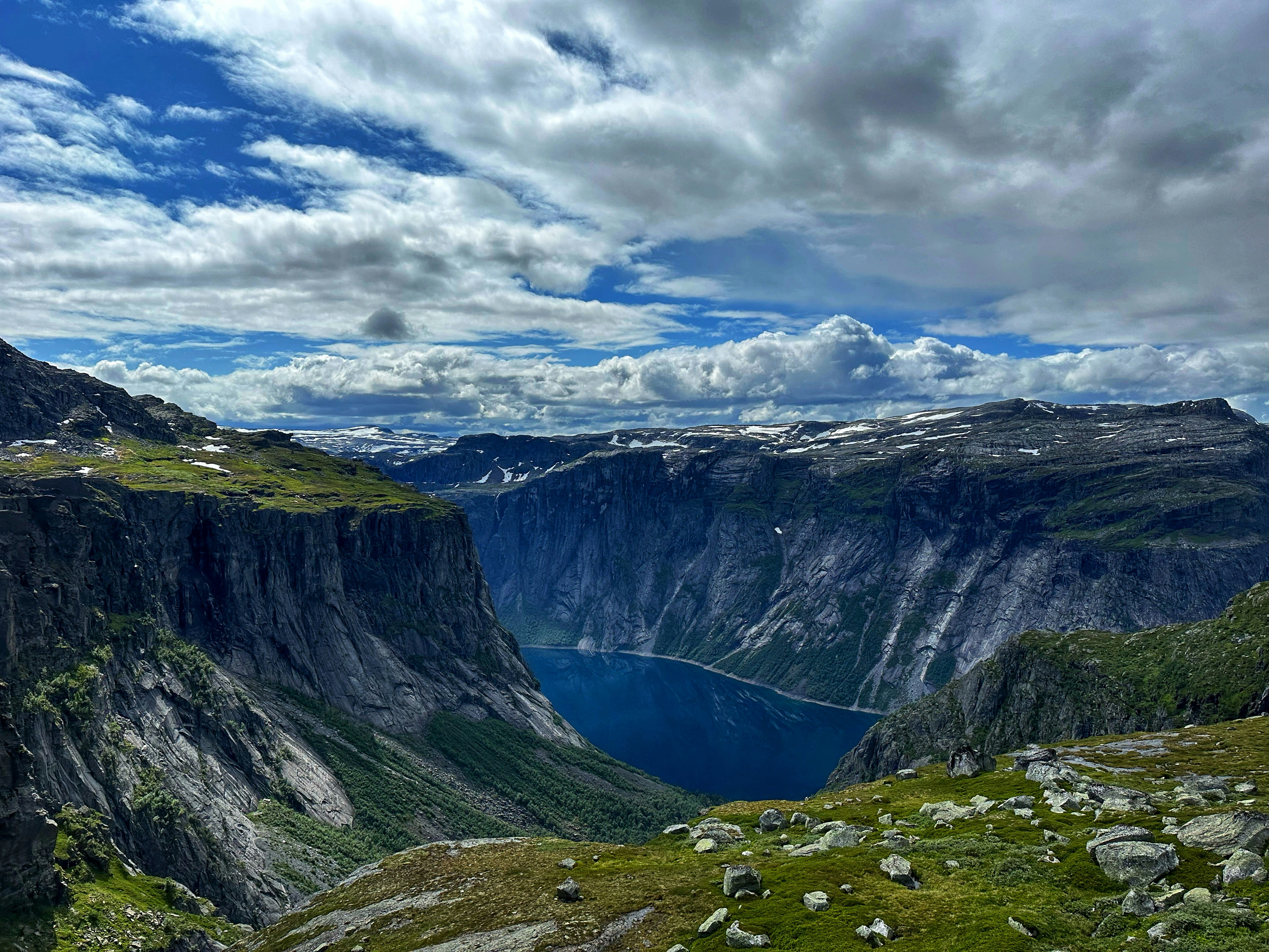 Norwegian fjord landscape with dramatic ridgeline and emerald lake below