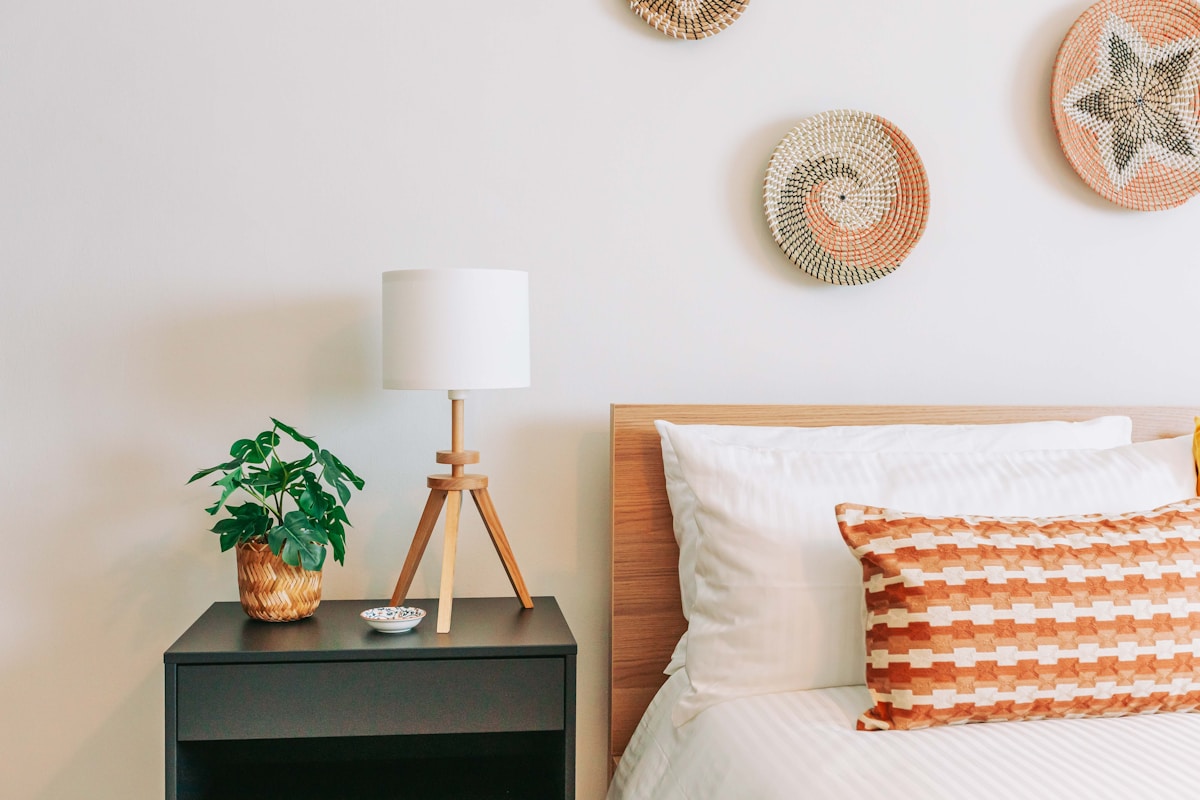 Cozy apartment bedroom with wooden headboard and wicker wall decor