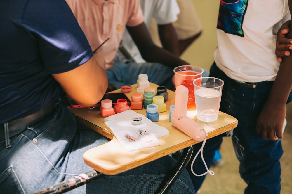 a group of people sitting around a table with bottles of liquid