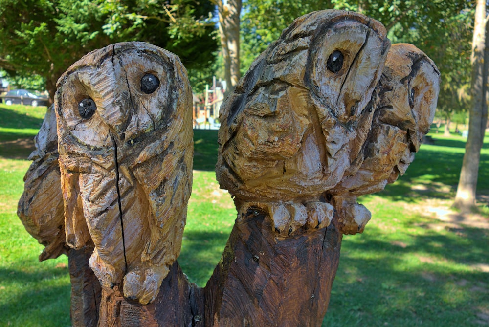 two carved owls sitting on top of a tree stump