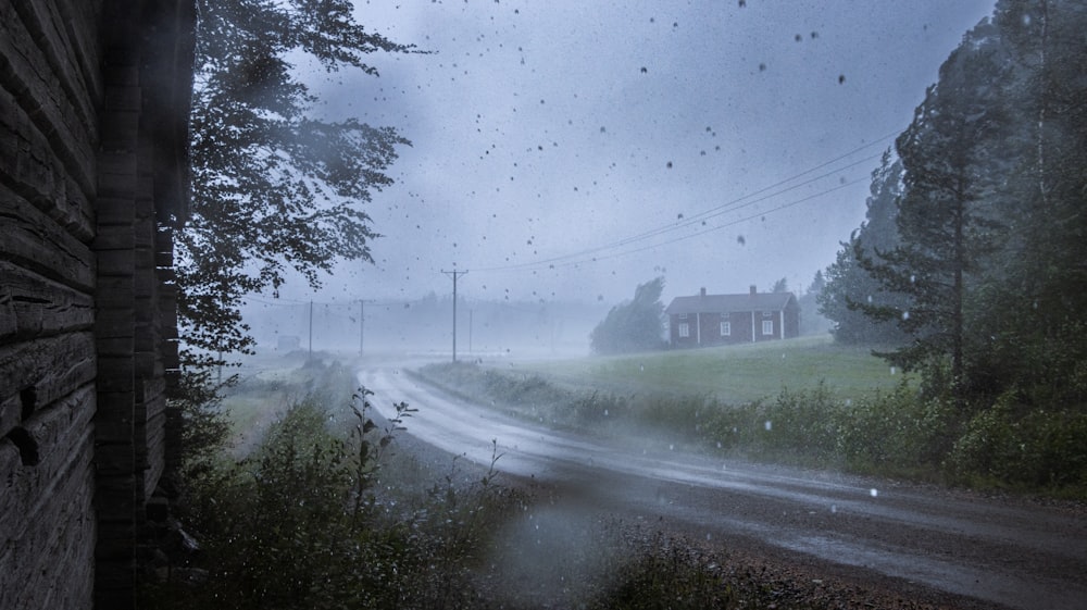 a house in the middle of a road on a rainy day