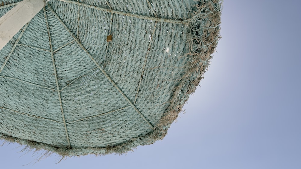 a close up of a green umbrella with a blue sky in the background