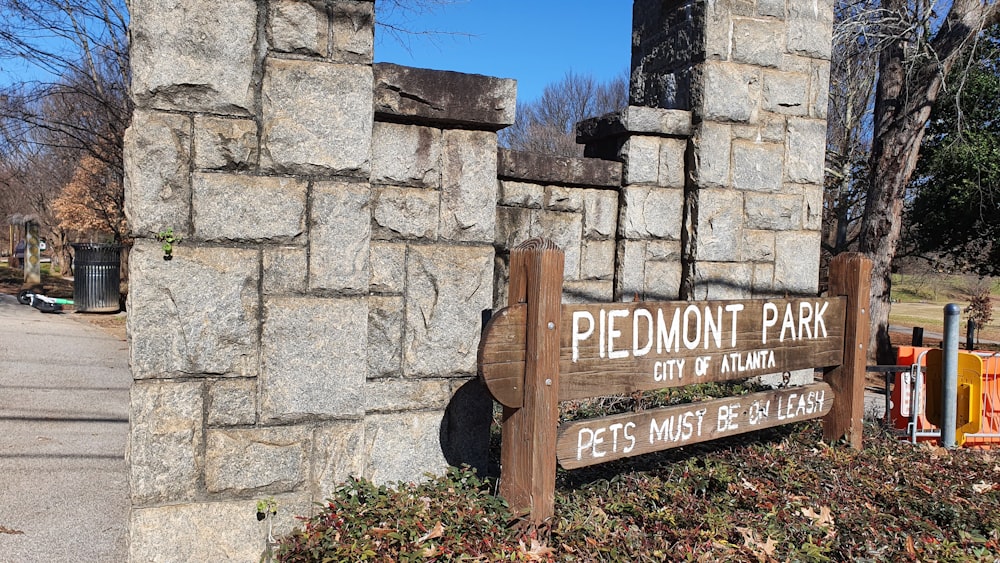 a sign is posted on a stone wall