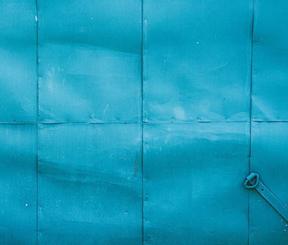 a close up of a blue metal wall