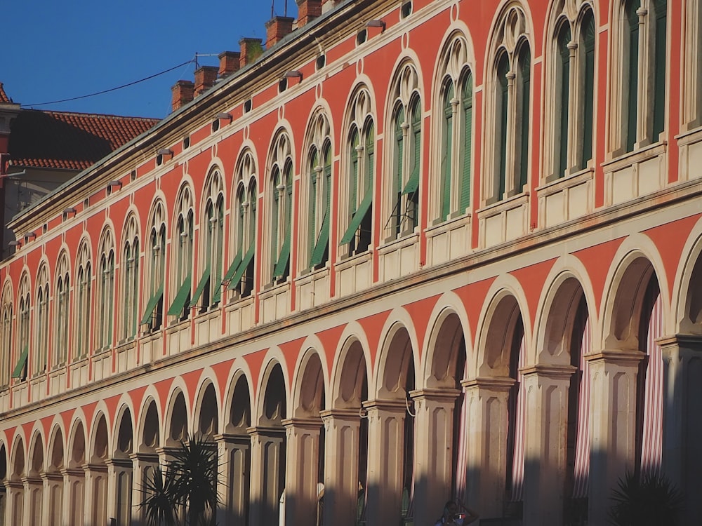 a building with arches and a clock on the side of it