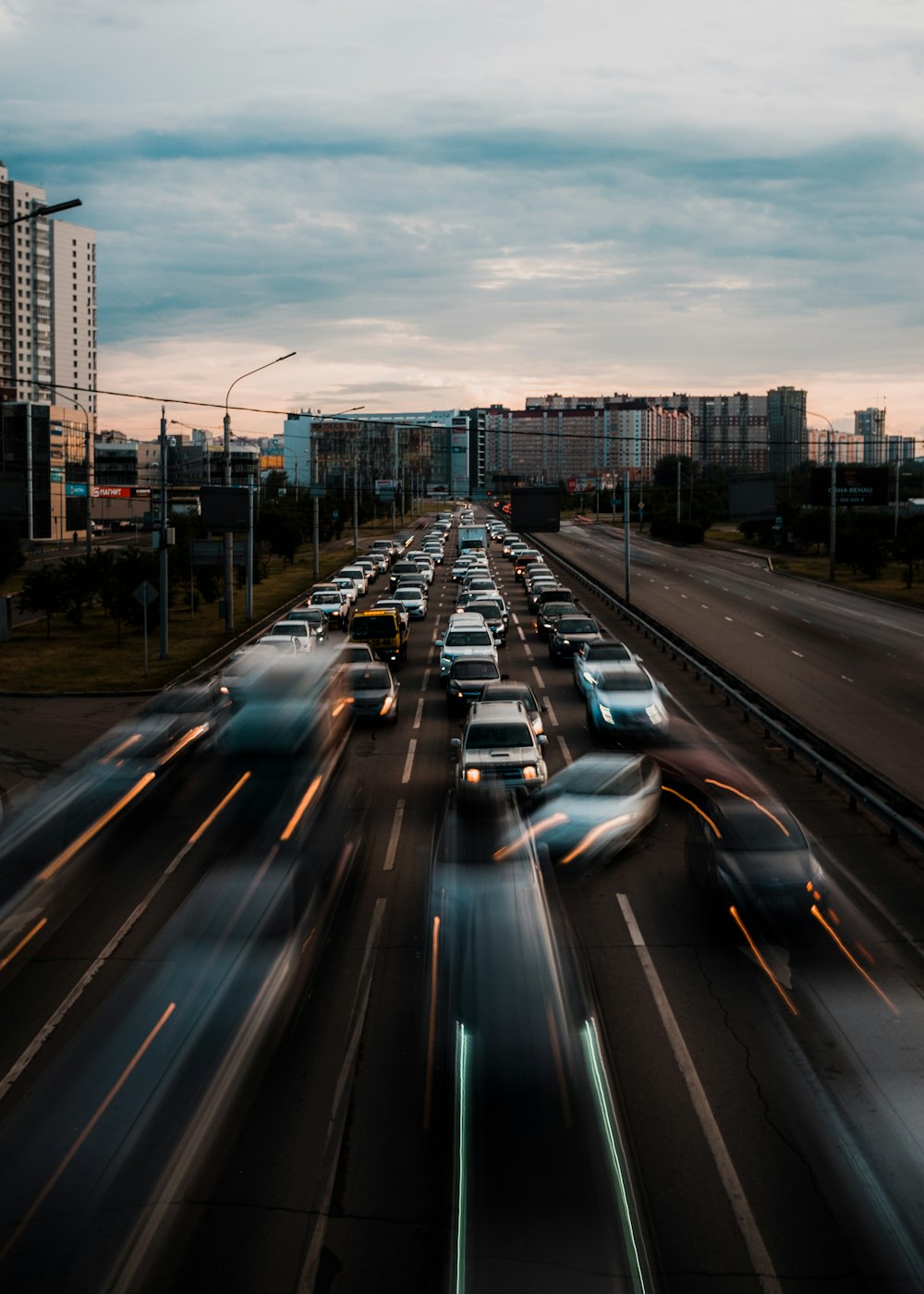 a highway filled with lots of traffic next to tall buildings