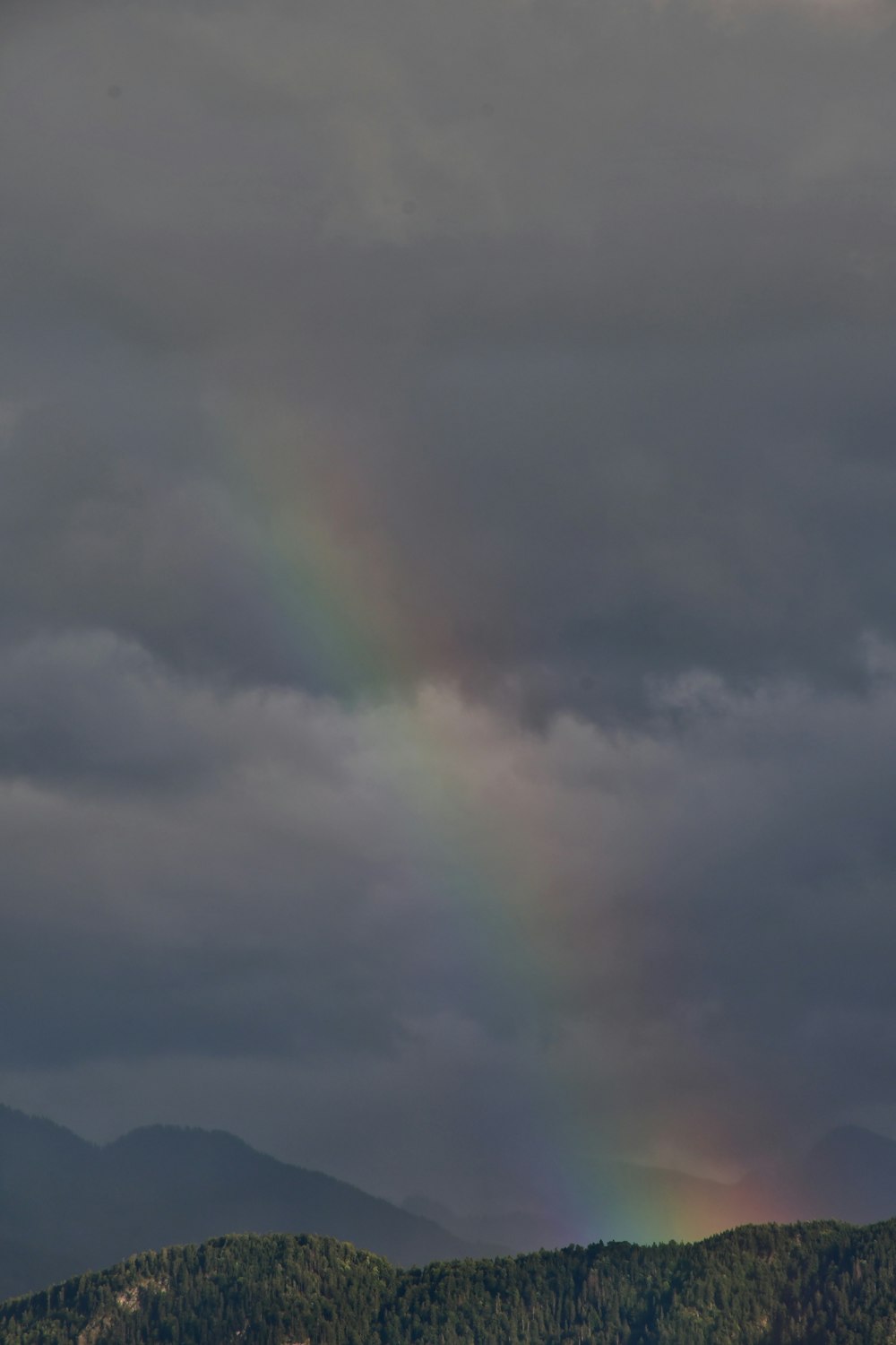 um arco-íris no céu sobre uma cordilheira