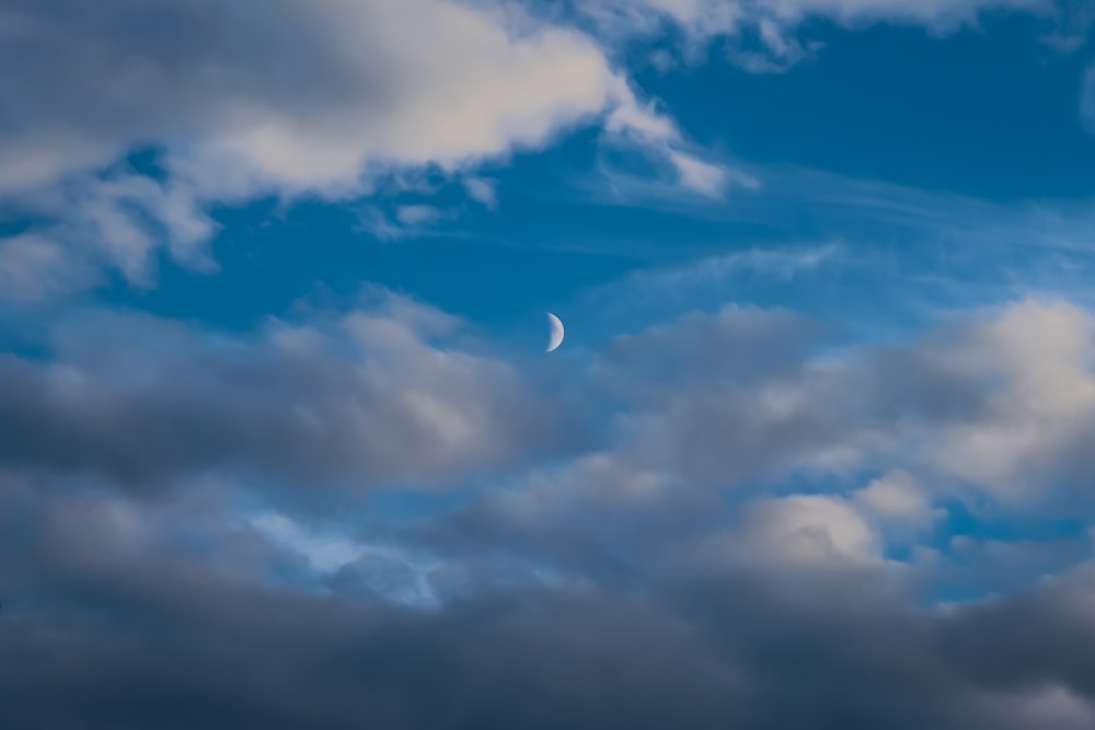 Ein Flugzeug, das am Himmel fliegt, mit einem Halbmond in der Ferne