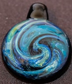 Hand-engraved glass pendant catching the light beautifully.