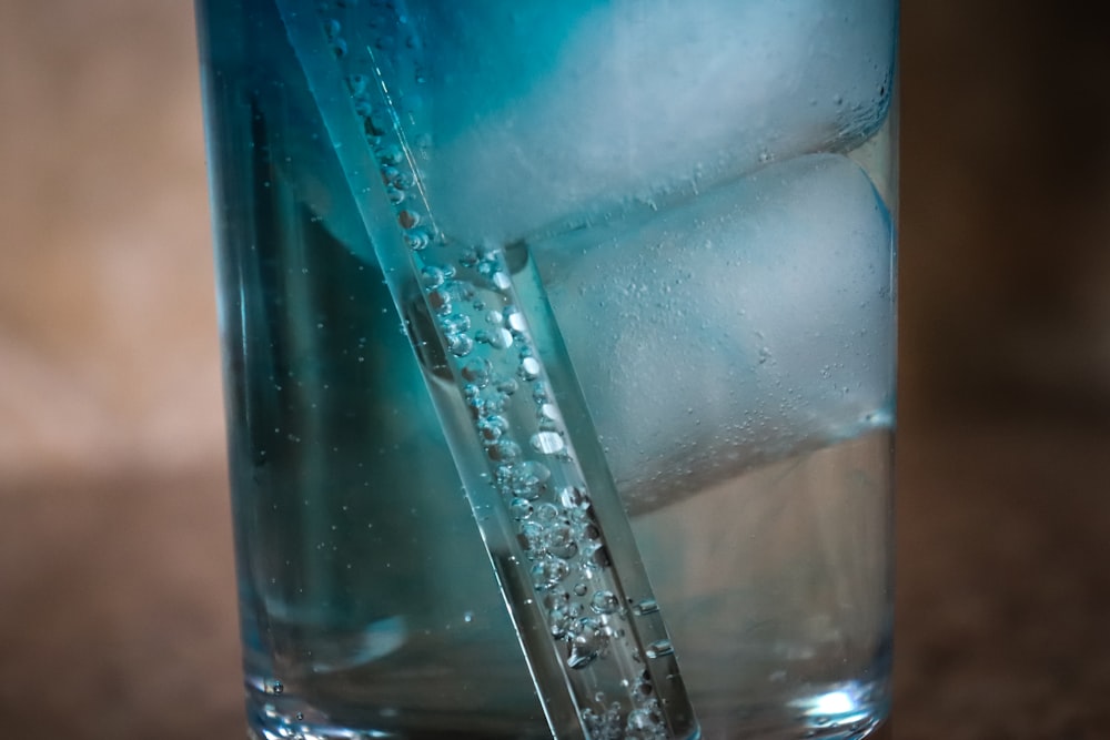 a glass of water with ice cubes in it