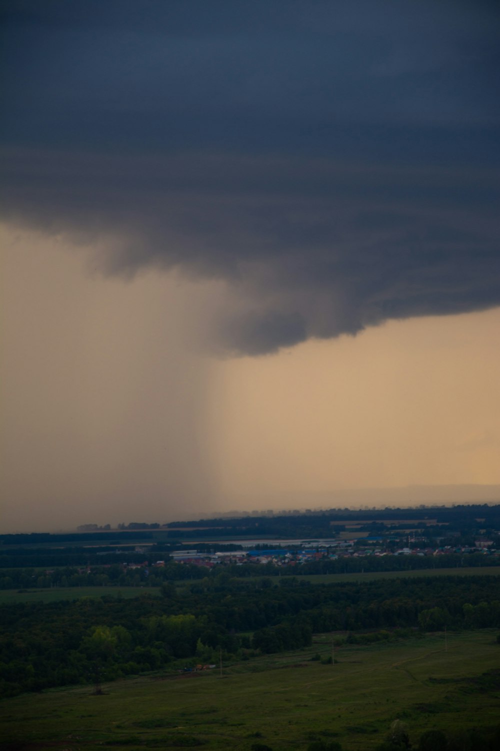 une grosse tempête se déplaçant dans le ciel au-dessus d’un champ