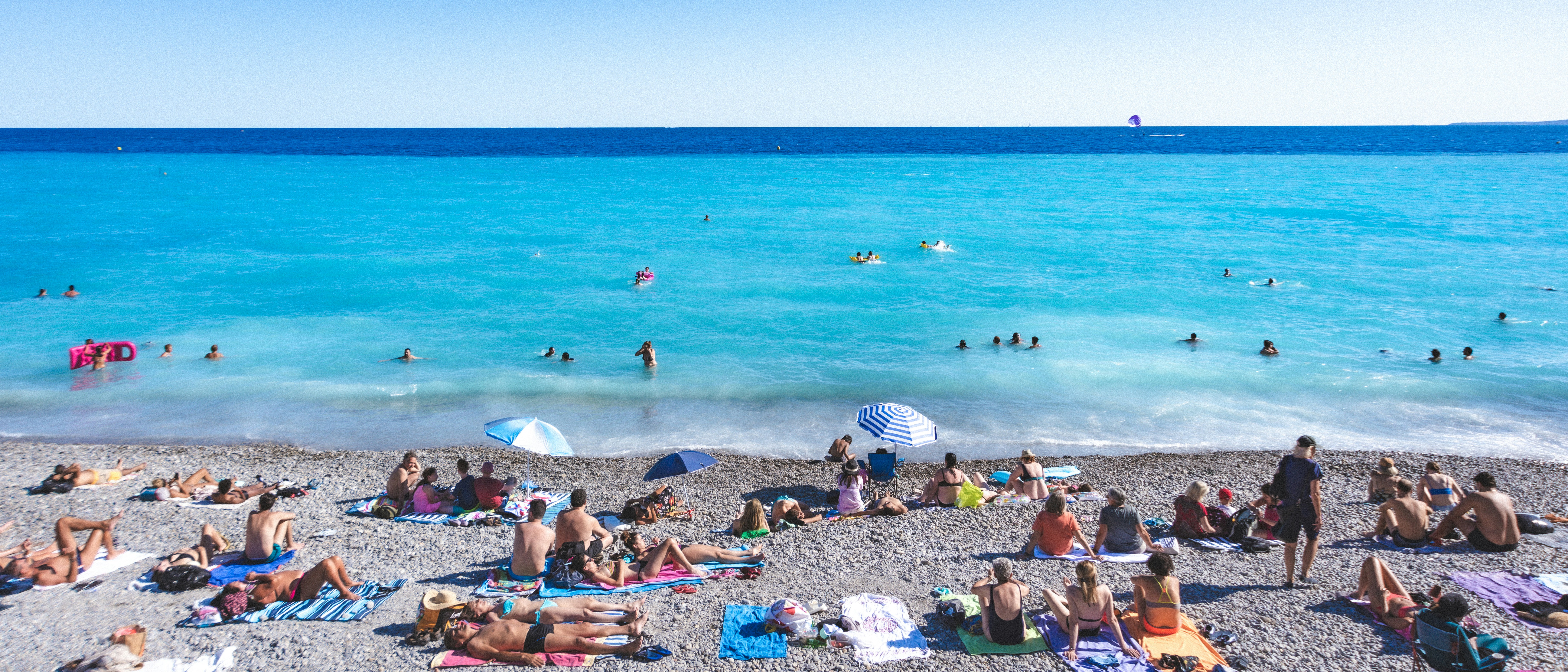 a group of people sitting on top of a sandy beach