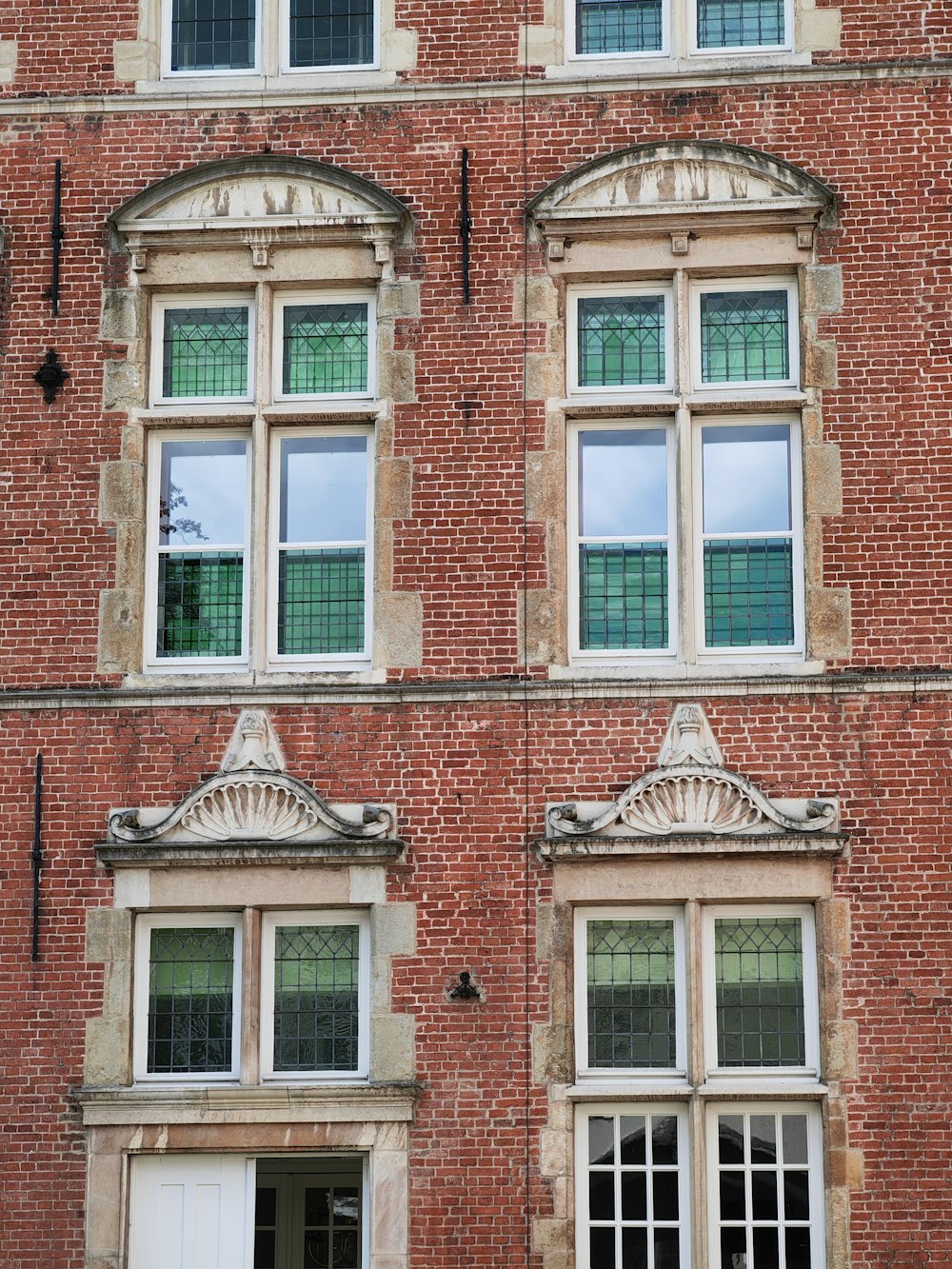 a red brick building with three windows and a clock