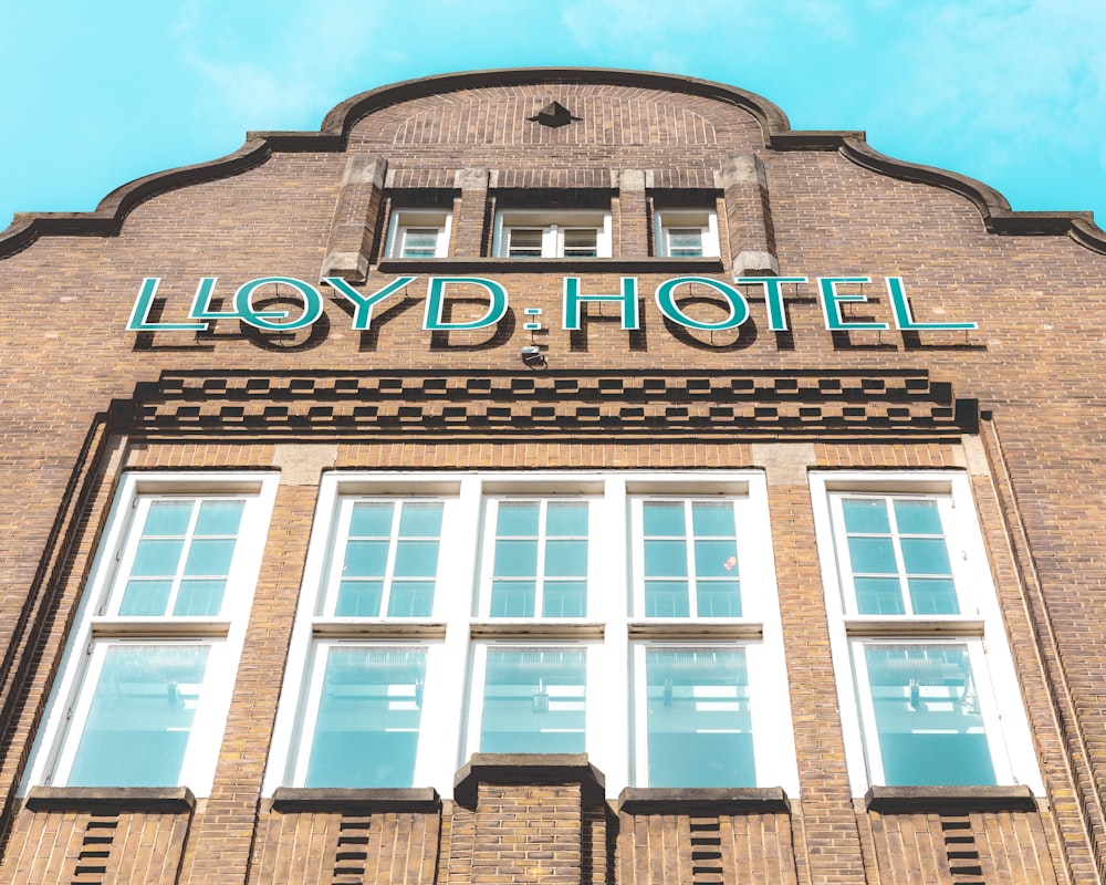 a tall brick building with windows and a sign that says lloyd hotel