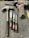 A collection of tools is arranged on a dark surface. An electric drill with the brand 'Hyper Tough' is visible alongside a claw hammer with a black handle. Three chisels of varying sizes, also branded 'Hyper Tough,' are aligned next to the hammer.